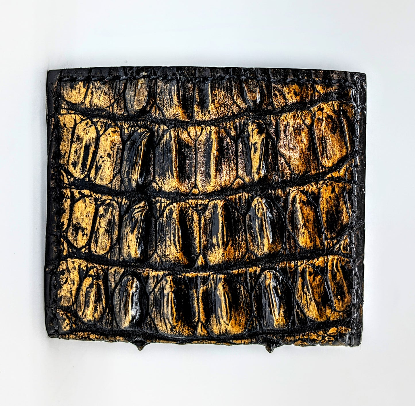 Textured black and gold rectangular object on a white background