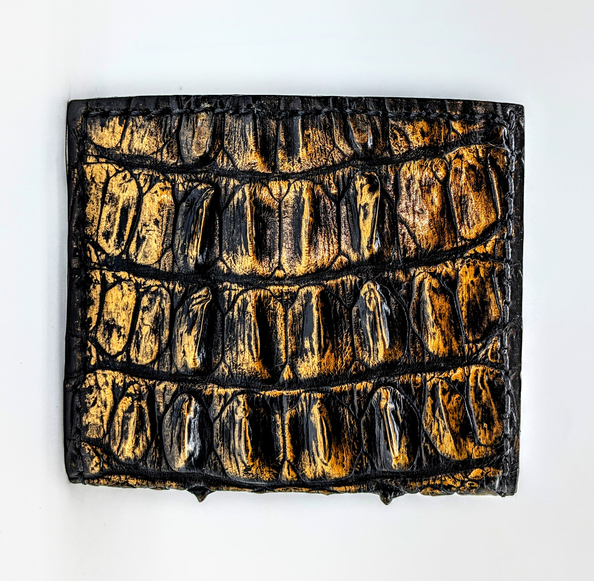 Textured black and gold rectangular object on a white background